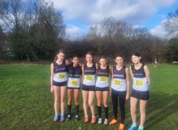 Highgate Harriers junior athletes in black and white club vests competing in the North West London Young Athletes League cross country race